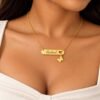 Personalized gold name necklace with heart cutout nameplate and dangling butterfly charm worn by a female model